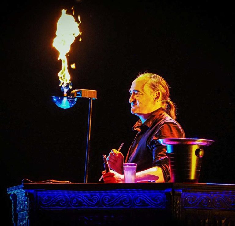 De brandende zeepbellen in de bubble show van Stephan Masurzeepbellenshow Een glimlachende circusartiest staat naast een brandende zeepbel.